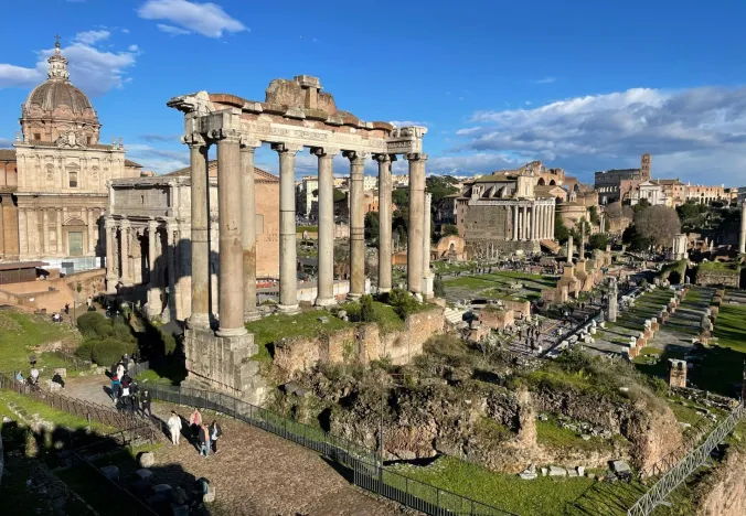 Vista panorámica del Foro Romano en Roma, Italia, con turistas explorando las ruinas antiguas.