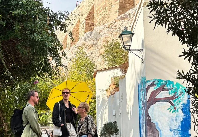 Turistas explorando Atenas, Grecia, cerca de la Acrópolis.