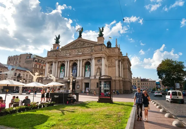 Tourists enjoying the sunny square in front of the magnificent Lviv Opera House in Ukraine.
