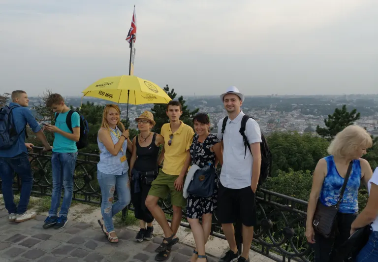 Un grupo de turistas en una visita guiada a pie en Lviv, Ucrania, disfrutando de una vista panorámica de la ciudad.