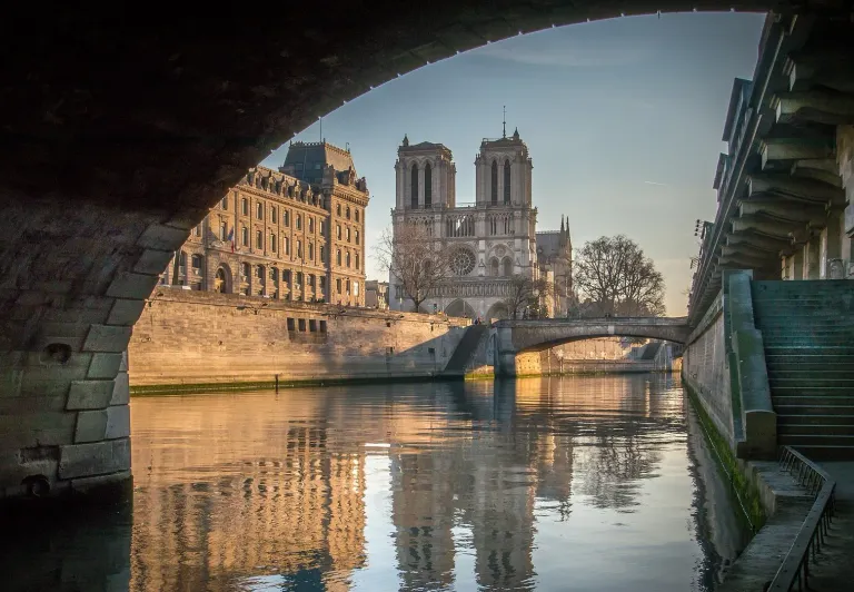 Atemberaubende Aussicht auf die Kathedrale Notre Dame in Paris, die sich im Fluss Seine spiegelt.