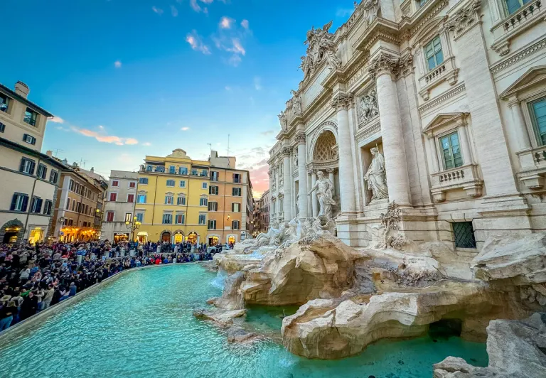 Tourists admiring the Trevi Fountain in Rome during a guided walking tour.