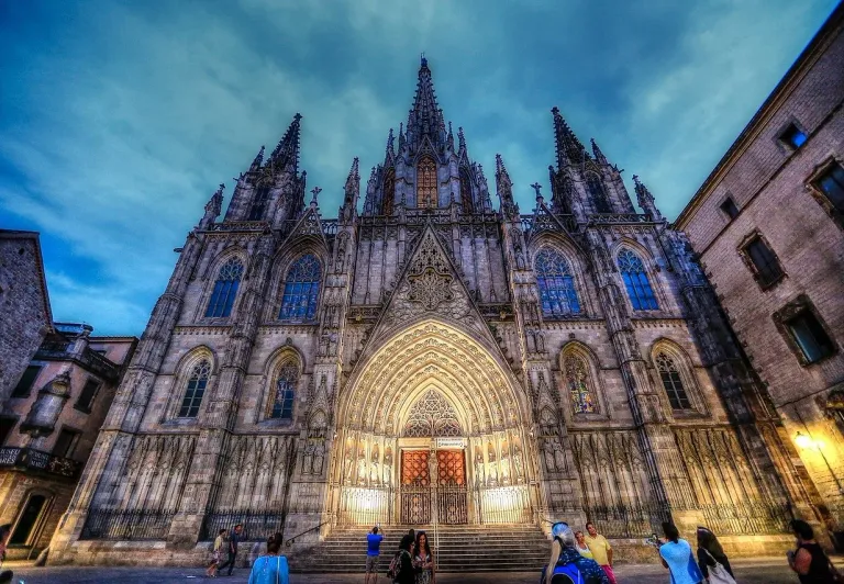 Catedral de Barcelona al atardecer, turistas admirando la arquitectura gótica.