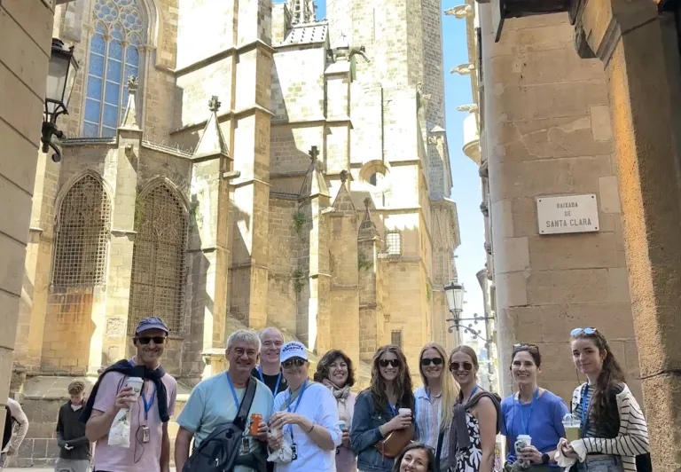 Barcelona Cathedral at dusk, tourists admiring the Gothic architecture.
