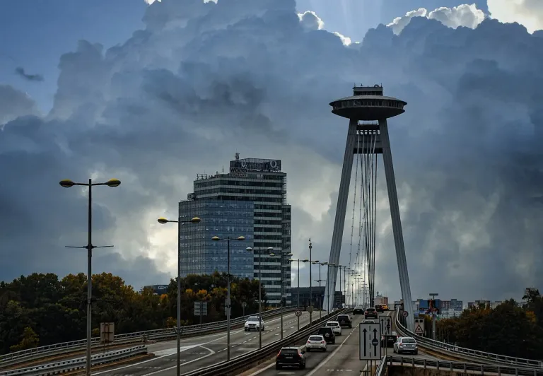 Vista dramática del Puente UFO y la torre de observación de Bratislava bajo un cielo tormentoso.