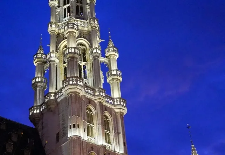 El Ayuntamiento de Bruselas por la noche, iluminado contra el cielo oscuro.