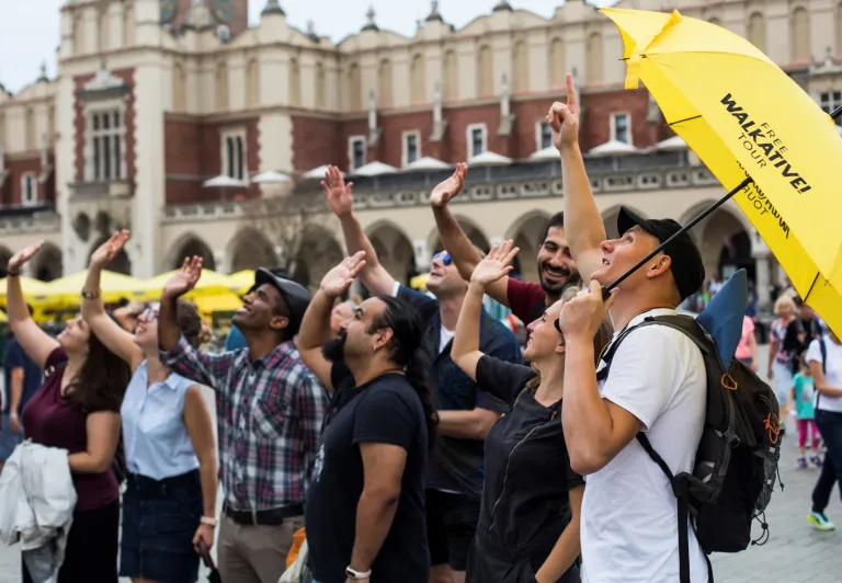 Un guía de Walkative! Free Tour conduce a un grupo de turistas en la Plaza Mayor de Cracovia.