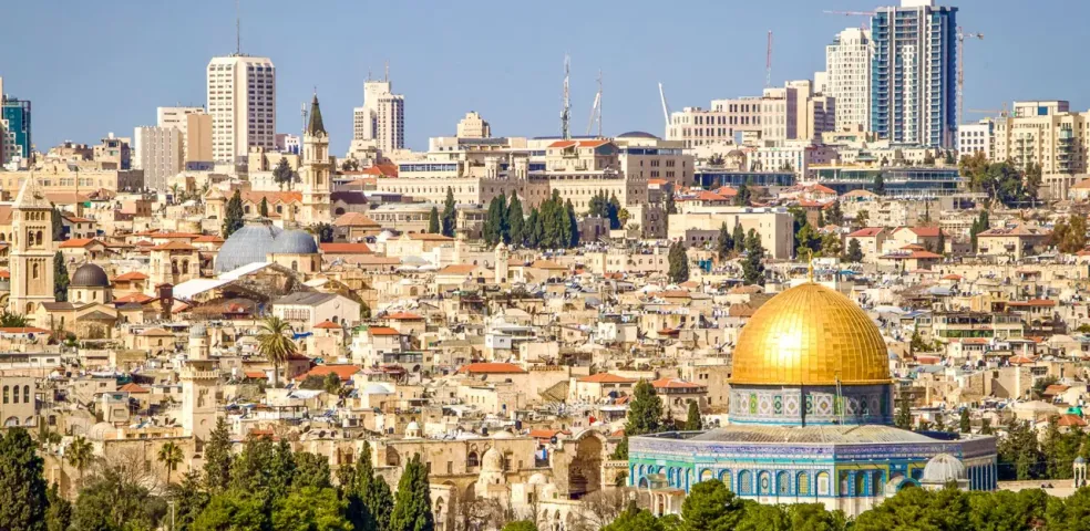 Vista de Jerusalén con la Cúpula de la Roca dorada en primer plano y los edificios de la Ciudad Vieja y rascacielos modernos