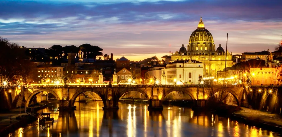 Stunning sunset view of St. Peter's Basilica and Ponte Sant'Angelo in Rome.