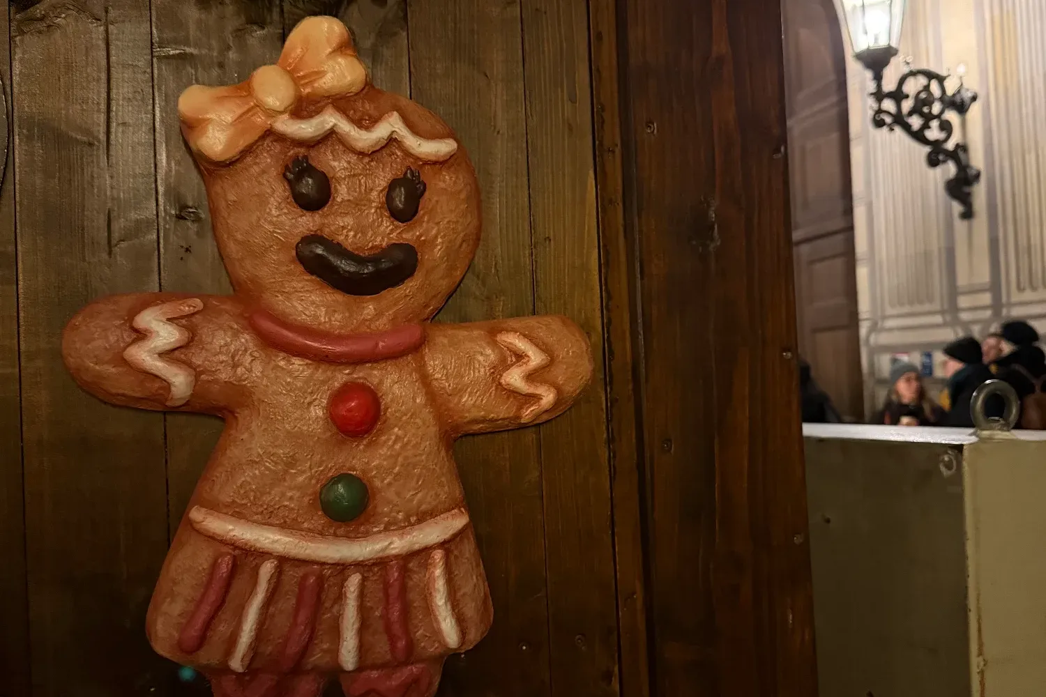 Lebkuchenfigur als Dekoration an einer Holzwand mit Tannenzweigen auf dem Münchner Weihnachtsmarkt.