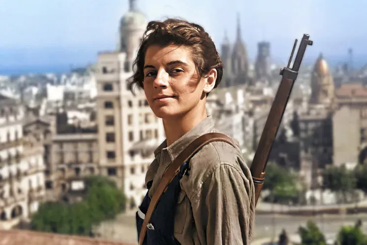 Junge Frau in historischer Kleidung mit Gewehr über der Schulter, auf einem Dach mit Blick auf Barcelonas Skyline.