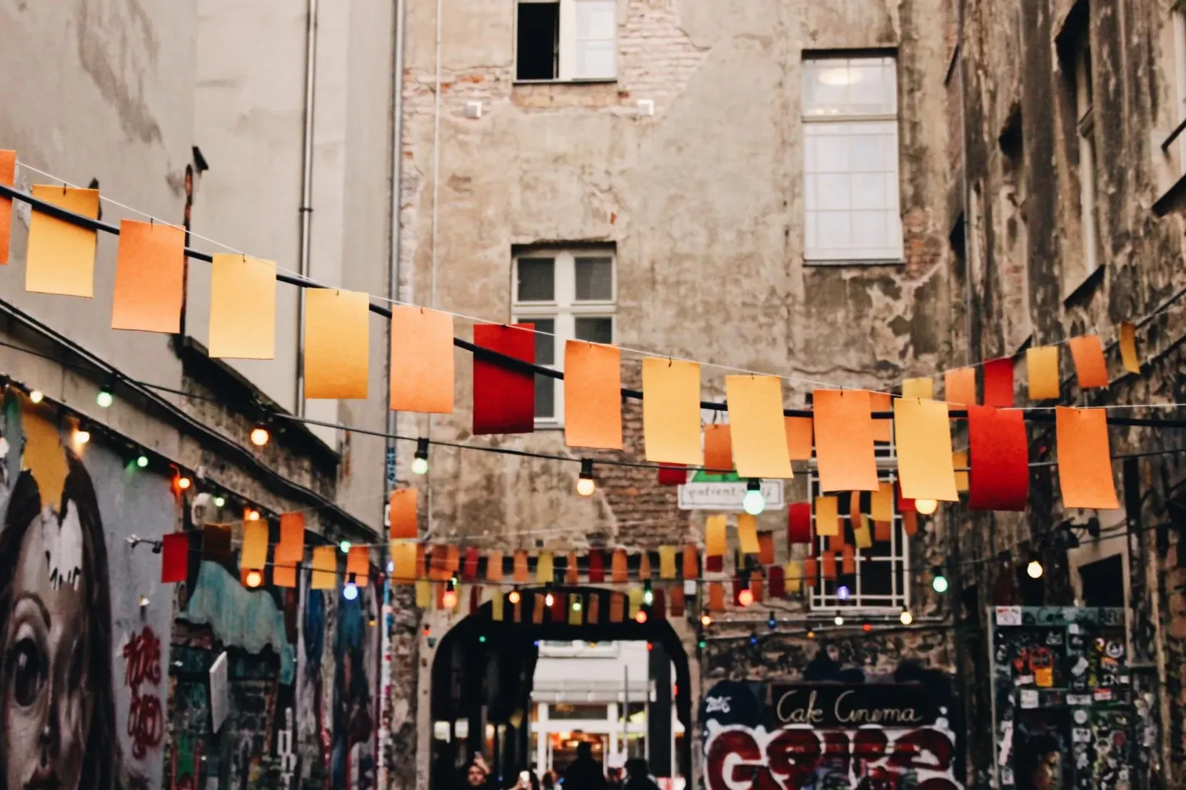 Buntfarbene Flaggen und Lichterketten beleuchten eine charmante Berliner Gasse.