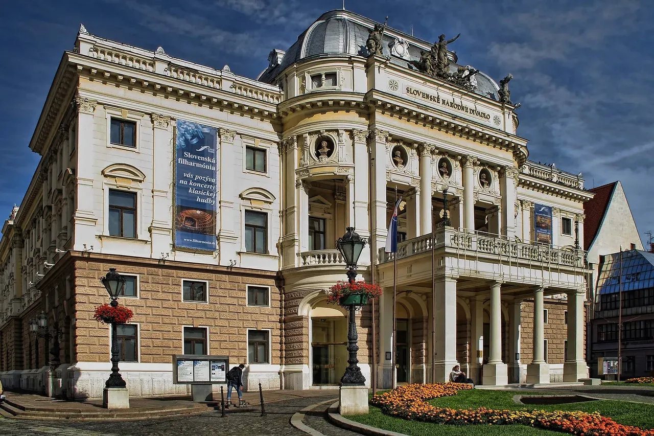 Gran edificio histórico del Teatro Nacional Eslovaco en Bratislava, con fachada clásica, columnas, cúpula y estatuas en el...