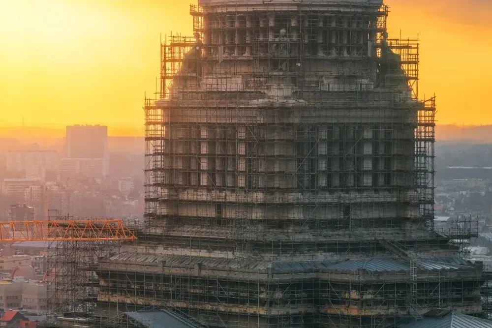El Palacio de Justicia de Bruselas, un gran edificio histórico, cubierto en su mayor parte por andamios oscuros al atardec...