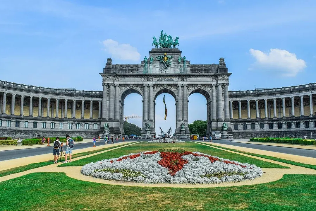 El Arco del Cincuentenario, un triple arco con una cuadriga de bronce, flanqueado por edificios con columnatas y un parque...