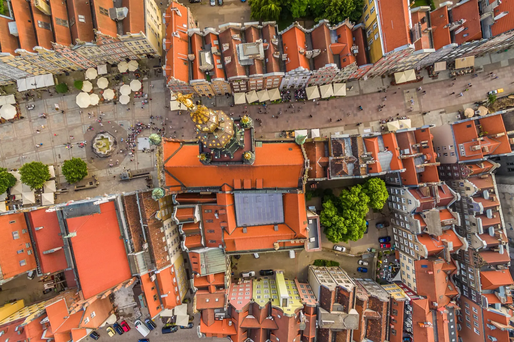 Vista aérea de la Plaza del Mercado Largo en Gdansk, con la Fuente de Neptuno, gente y edificios históricos de techos rojos.
