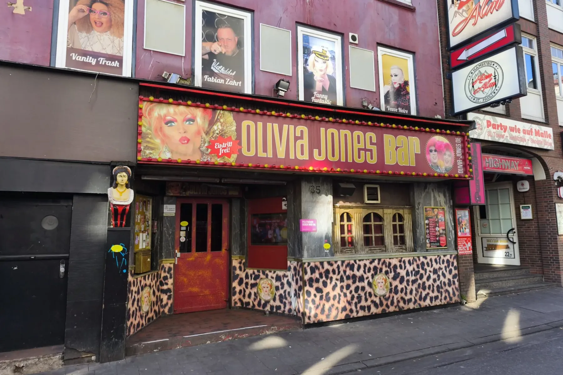 Exterior del Olivia Jones Bar en Hamburgo, con una fachada vibrante de estampado de leopardo, grandes letreros con imágene...