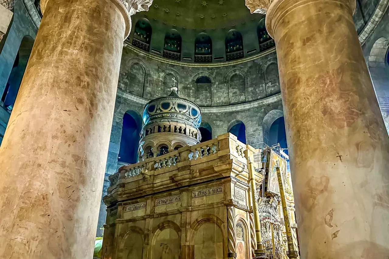 El Edículo del Santo Sepulcro en Jerusalén, enmarcado por dos grandes columnas de mármol bajo una cúpula abovedada.