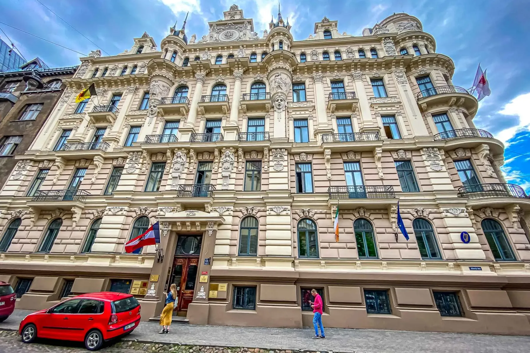 Verziertes Jugendstilgebäude in der Alberta-Straße in Riga, mit dekorativer Fassade, Balkonen und verschiedenen Flaggen. E...