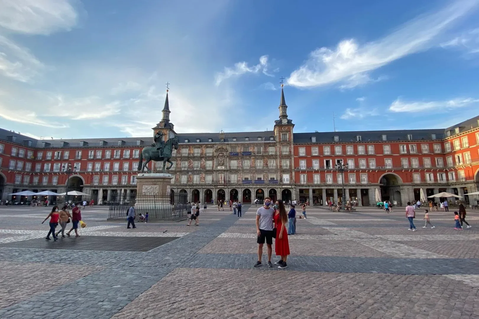 Estatua ecuestre de Felipe III en el centro de la Plaza Mayor de Madrid, rodeada de edificios rojos con ventanas blancas b...