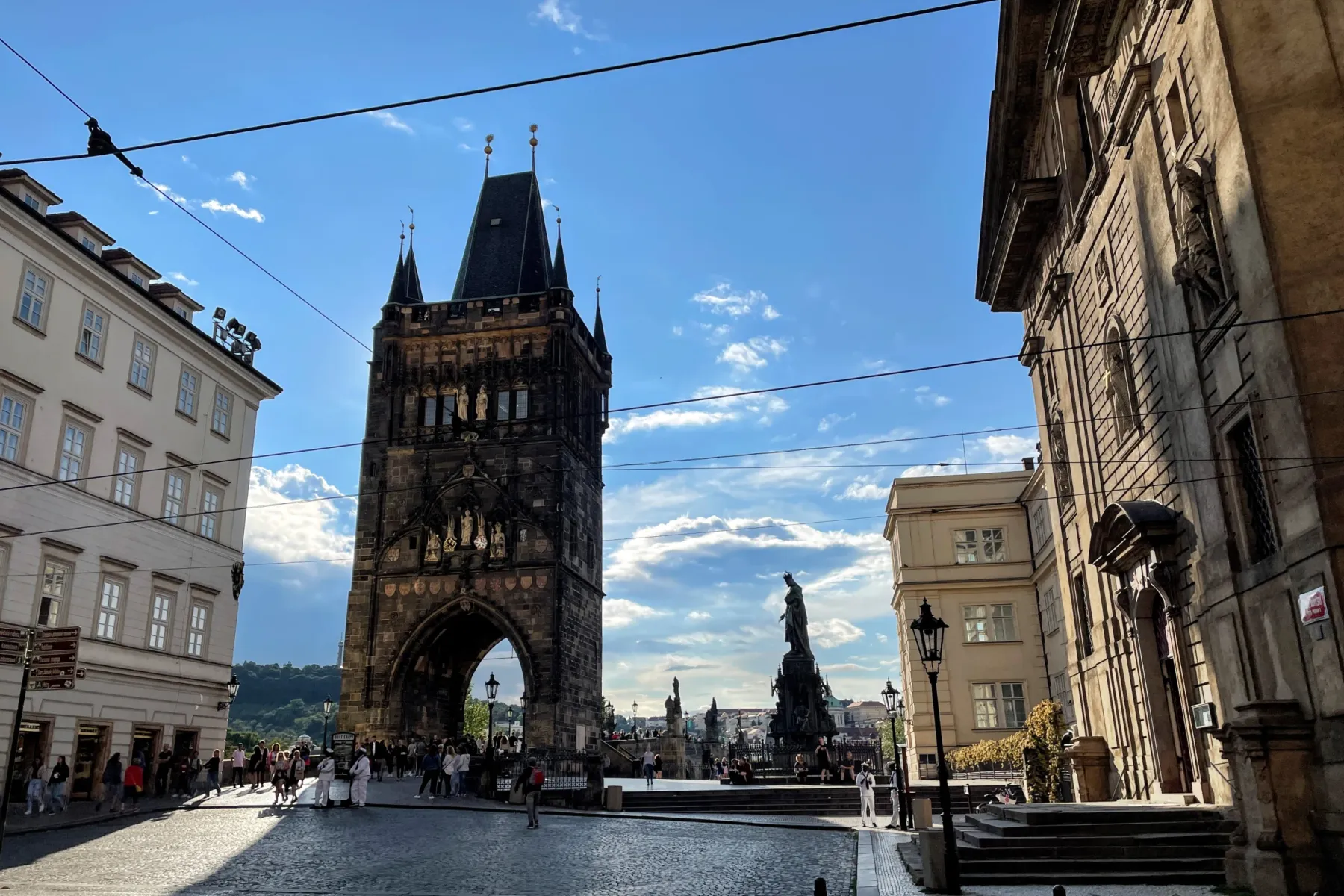Vista de la Torre del Puente de la Ciudad Pequeña y estatuas del Puente de Carlos en Praga, con edificios históricos y cal...