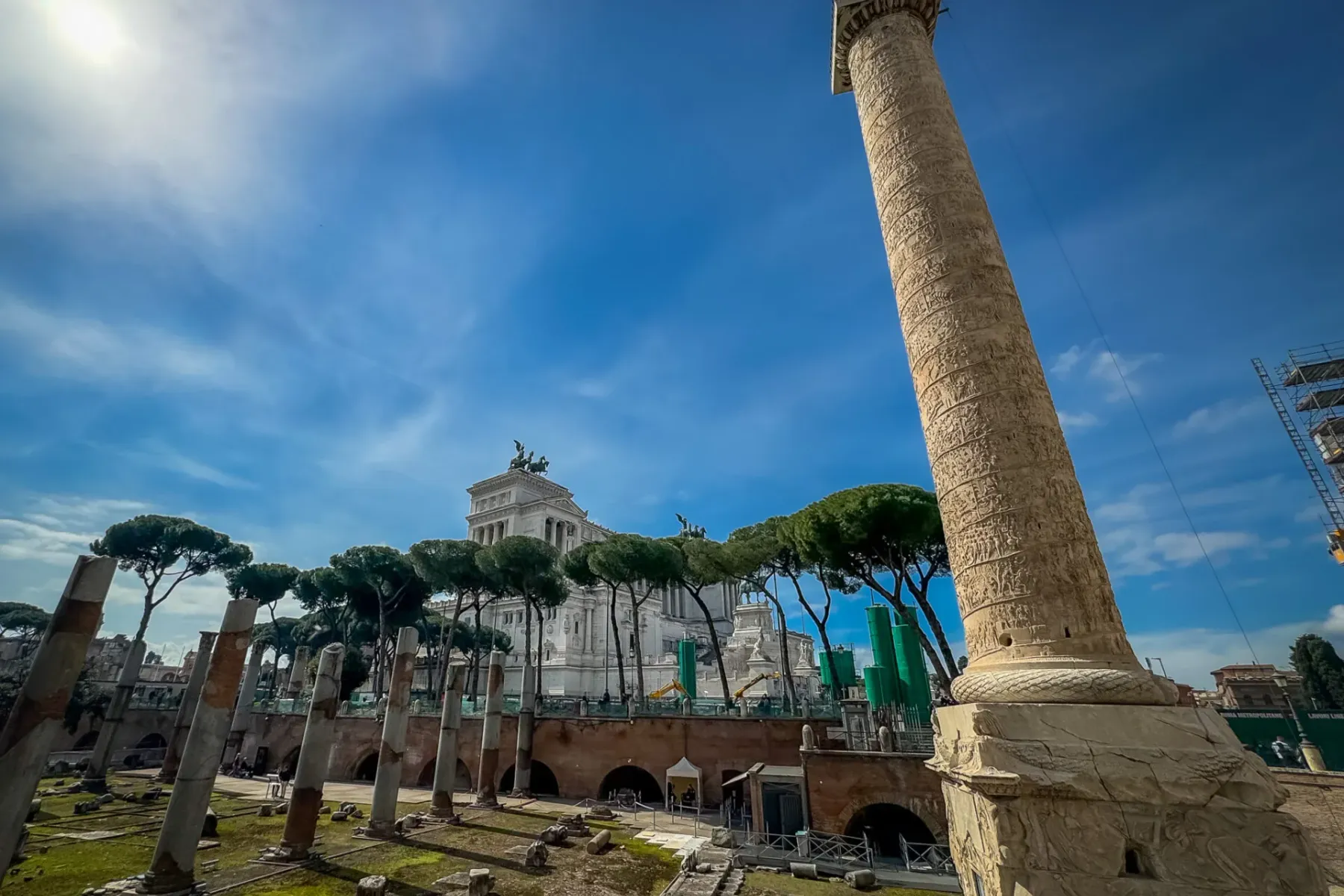 Trajanssäule mit detailreichen Reliefs, antike römische Ruinen im Vordergrund und das Altare della Patria im Hintergrund u...
