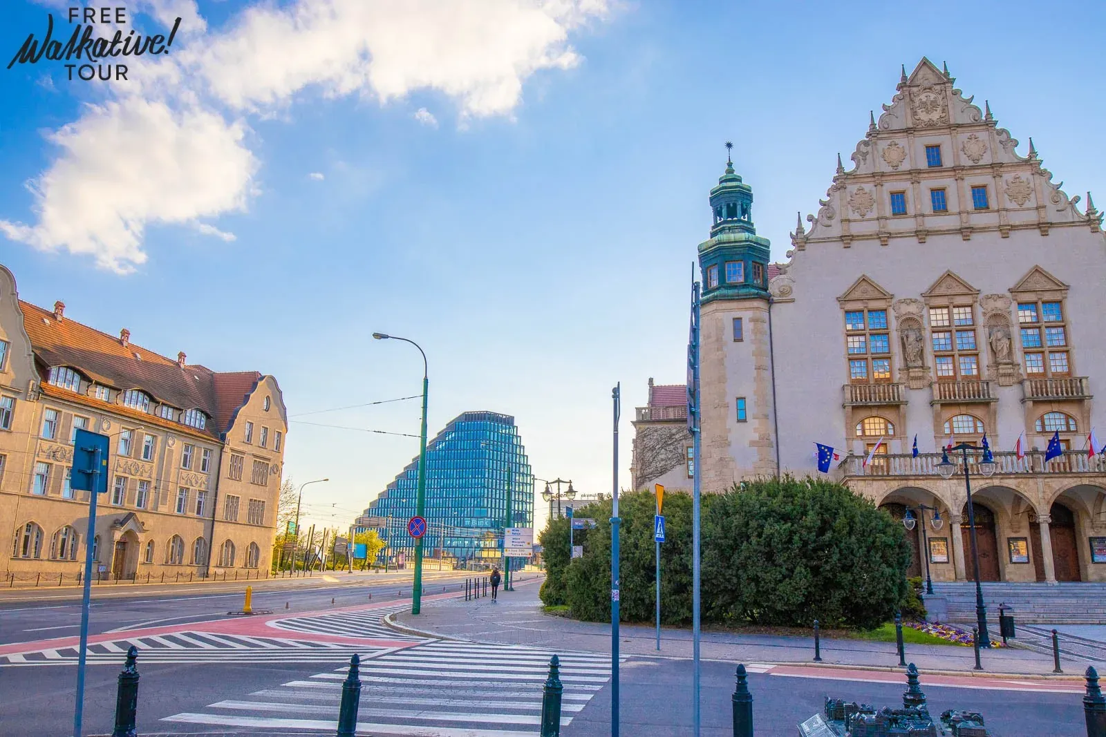 Skrzyżowanie ulic w Poznaniu z historycznym budynkiem Collegium Minus i nowoczesnym szklanym biurowcem Baltyk Tower pod bł...