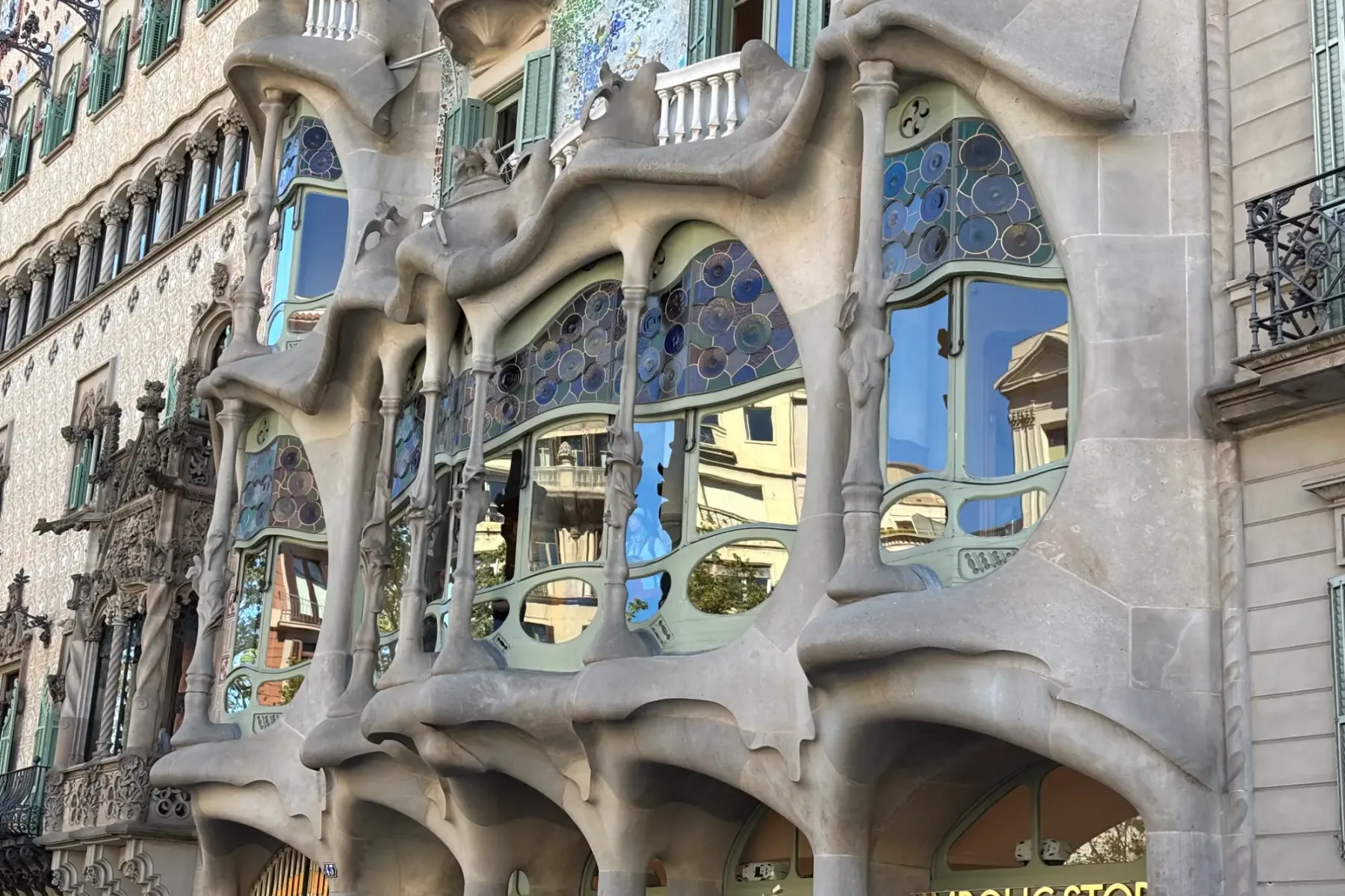 Zbliżenie na fasadę Casa Batlló w Barcelonie, ukazujące unikalne, kościste kolumny i kolorowe witraże Gaudiego.