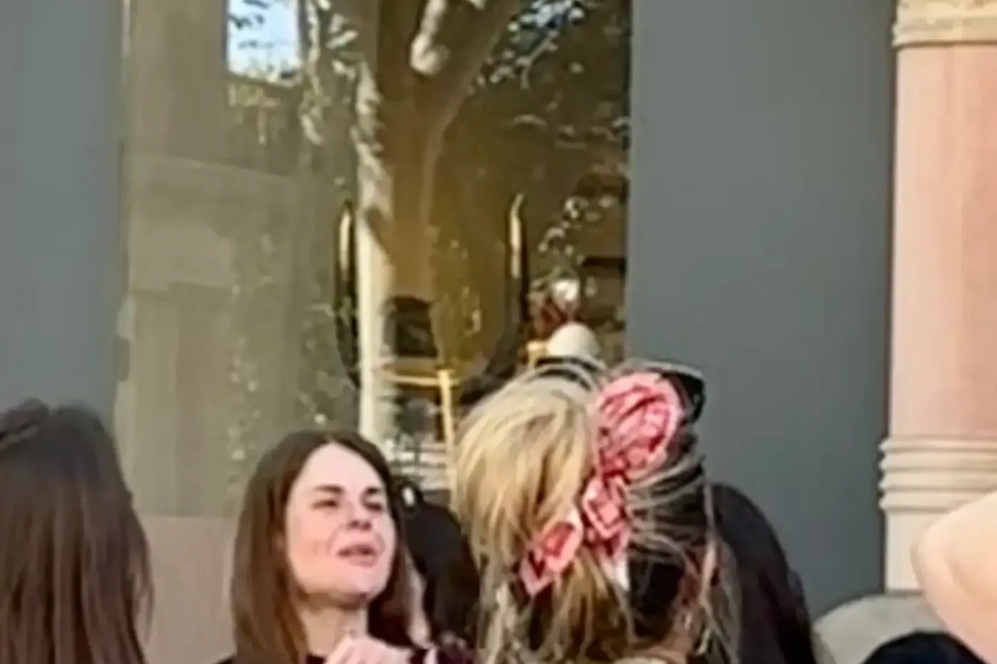 Personas en una calle de Barcelona, frente a la fachada de una tienda Loewe con detalles arquitectónicos ornamentados, bal...