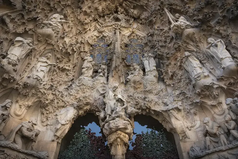 Highly detailed stone facade of Sagrada Familia's Nativity Facade, featuring numerous religious sculptures, intricate carv...