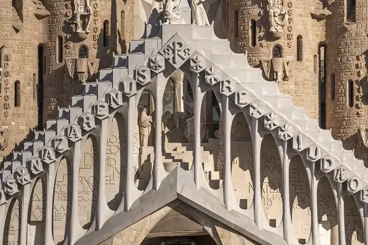 Close-up of Sagrada Família Passion Façade with geometric forms, vertical towers, and carved religious sculptures.