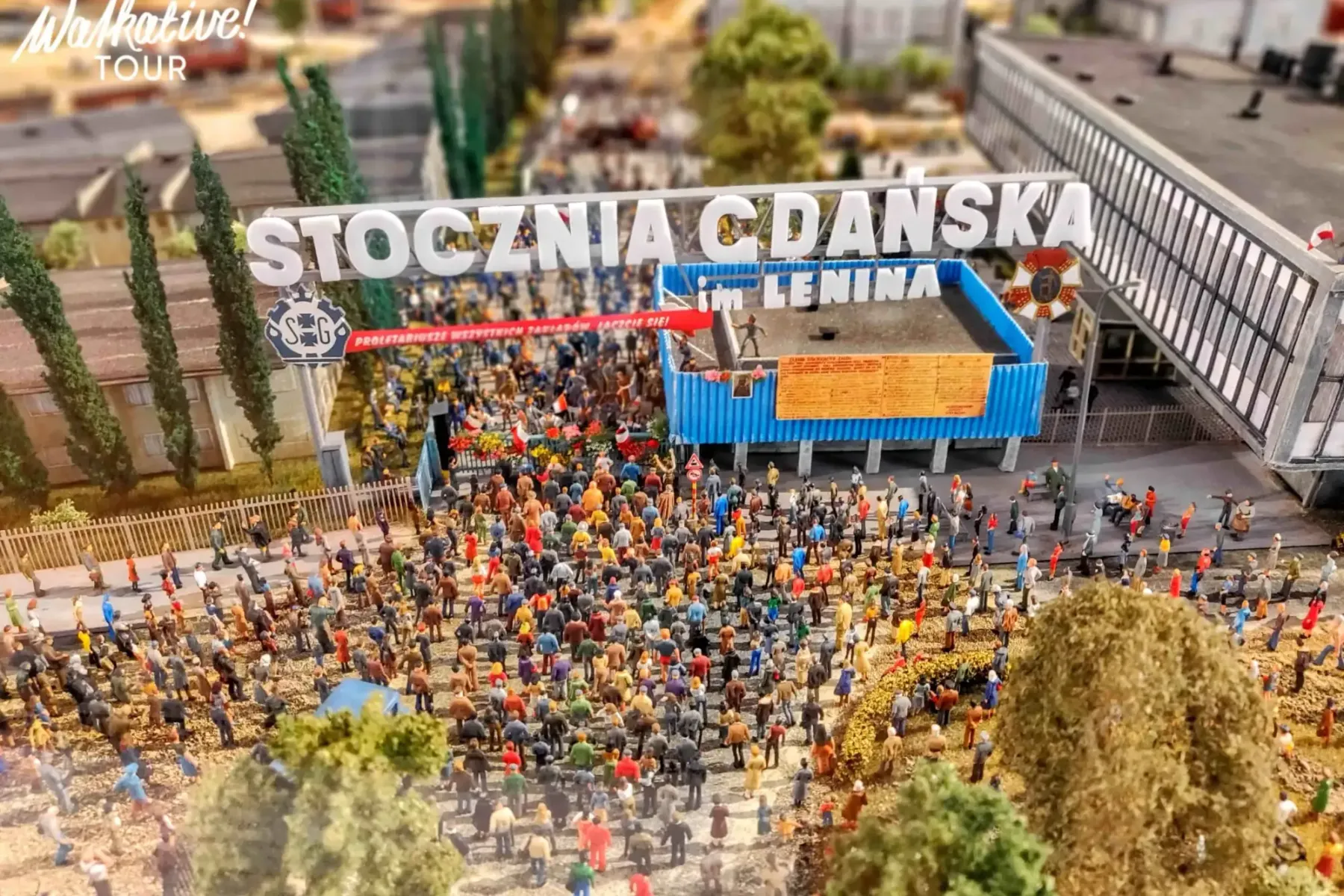 Miniaturmodell der Danziger Werft mit einer Menschenmenge unter dem Schild "STOCZNIA GDAŃSKA im. LENINA".