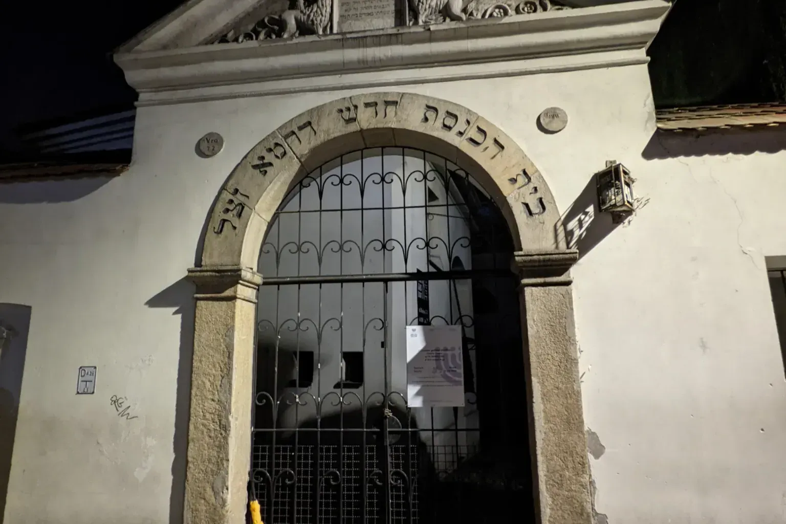 Entrada de piedra de la Sinagoga de Isaac en el barrio de Kazimierz de Cracovia por la noche, con inscripciones hebreas.