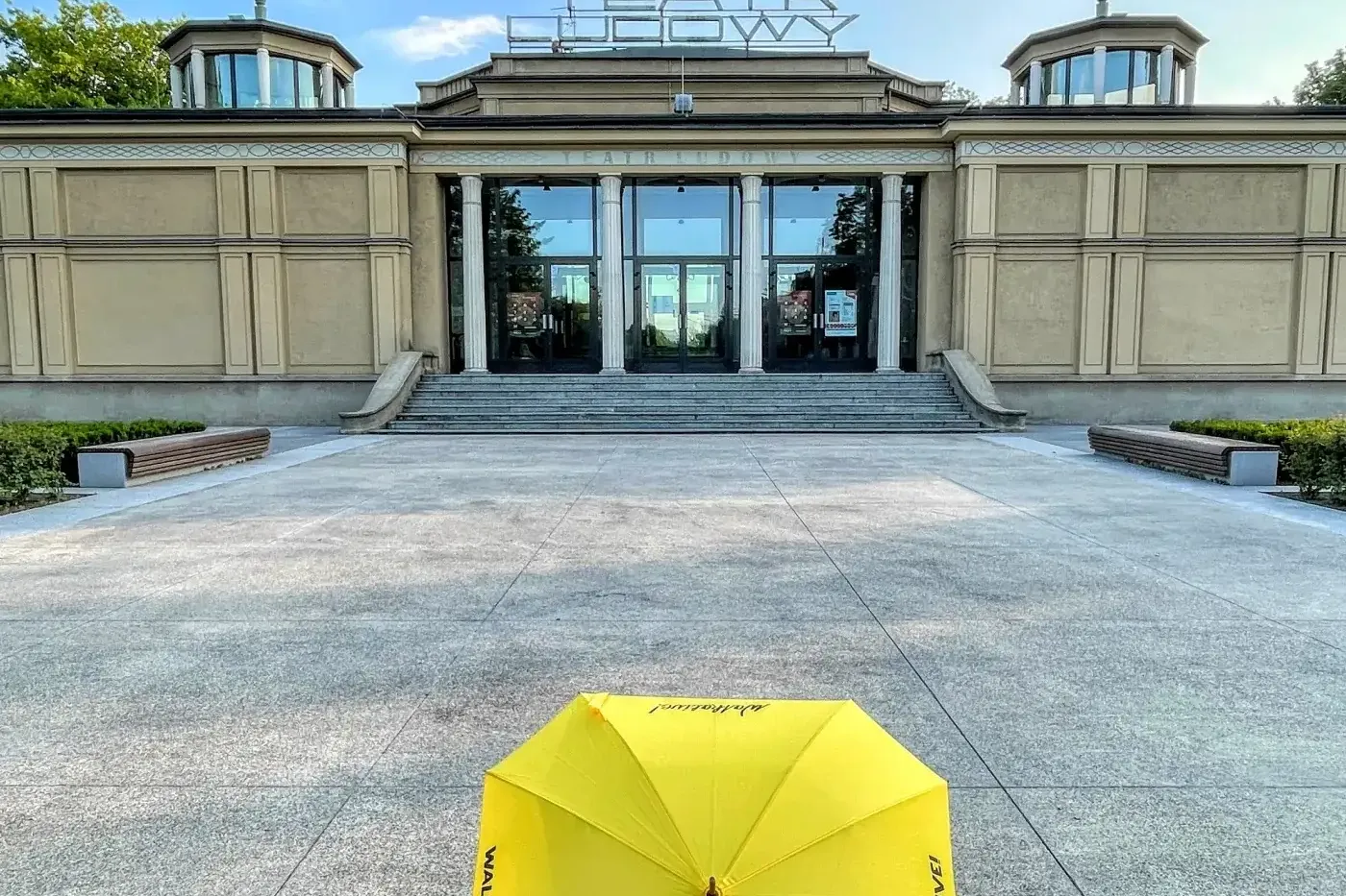 Ein gelber Walkative-Regenschirm auf dem Platz vor dem Volkstheater (Teatr Ludowy) im Krakauer Stadtteil Nowa Huta.