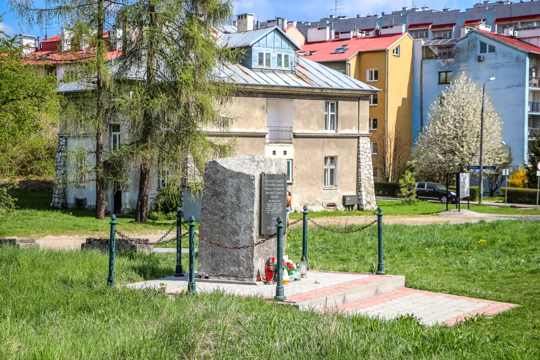 Ein Gedenkstein auf einer Wiese vor dem historischen Grauen Haus auf dem Gelände des ehemaligen KZ Plaszow in Krakau.