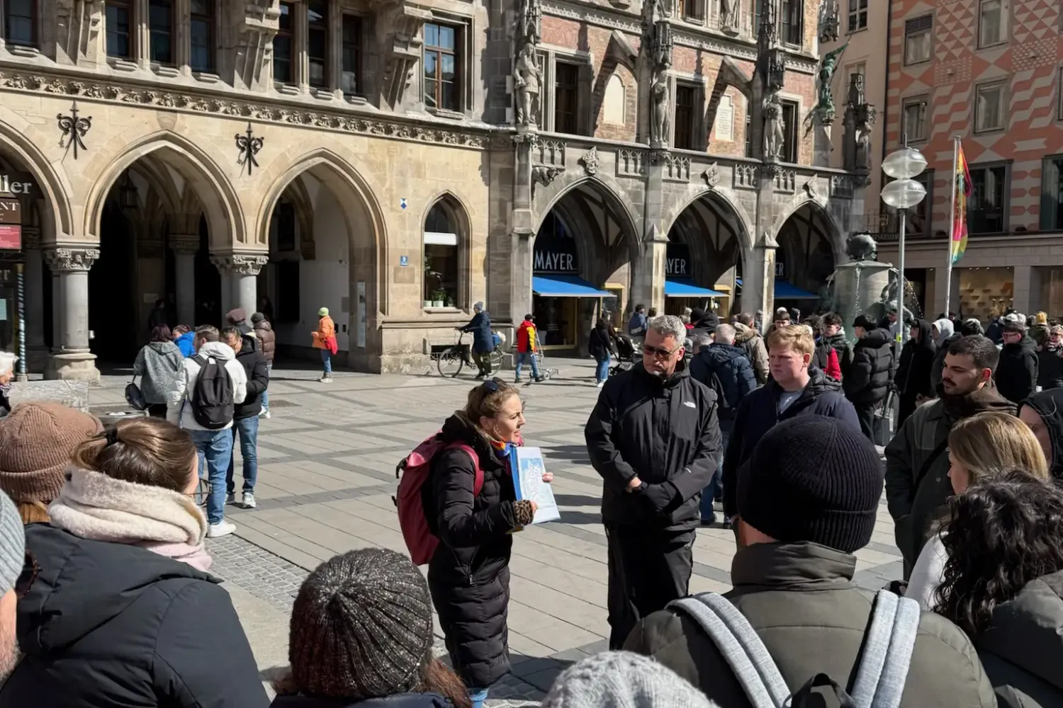 A tour guide talks to a group of tourists in Marienplatz square, in front of Munich's New Town Hall.