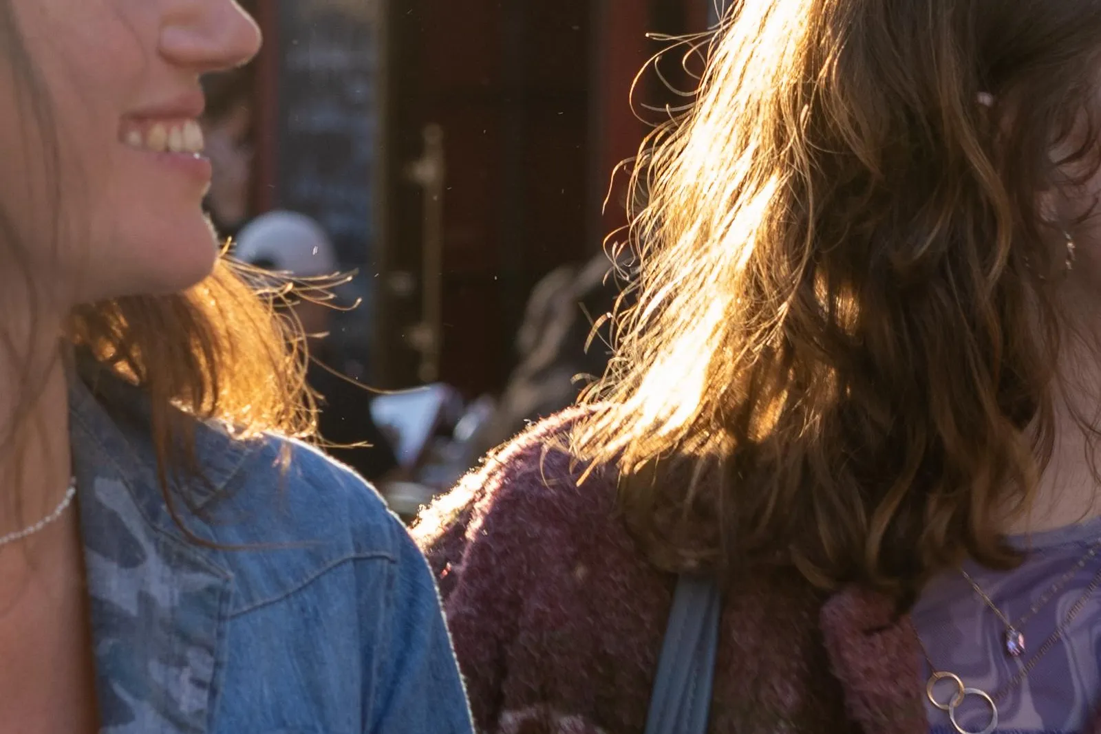 Dos personas con cabello iluminado por el sol frente al restaurante La Mère Catherine en Montmartre, París.