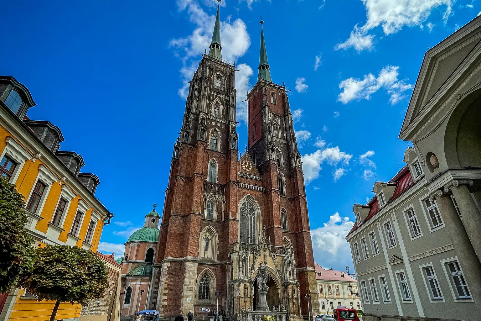 Wrocław Cathedral, a stunning Gothic landmark, stands tall against a vibrant blue sky.