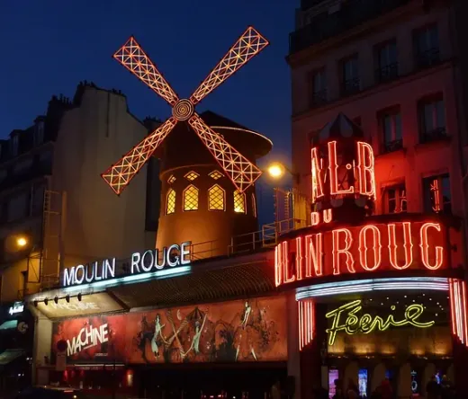 Olśniewający Moulin Rouge w Paryżu nocą.
