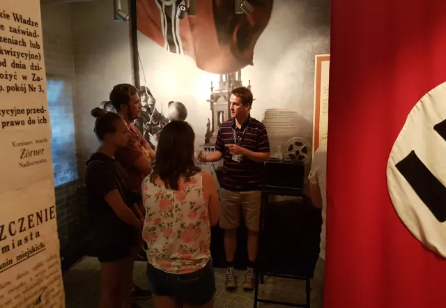 Grupo de turistas escuchando a un guía en una exposición de museo.