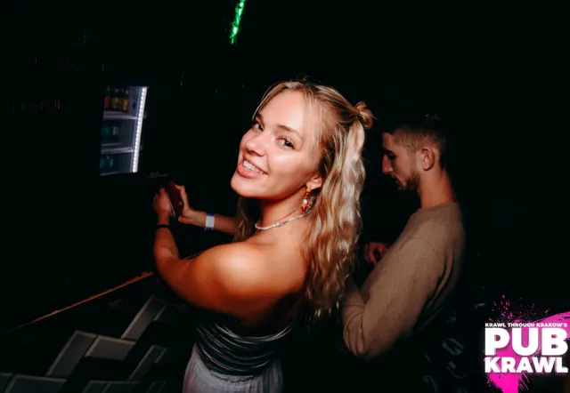 Mujer sonriendo en un pub crawl en Cracovia, Polonia.