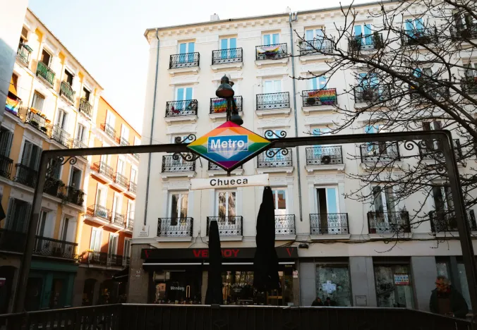 Madrider Chueca-Viertel: Ein lebendiges U-Bahn-Schild und farbenfrohe Gebäude.