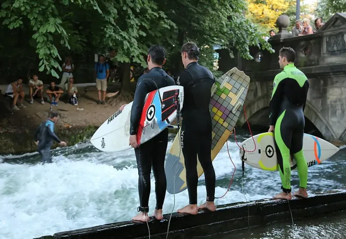 Surfer bereiten sich darauf vor, die Eisbachwelle im Englischen Garten in München zu reiten.