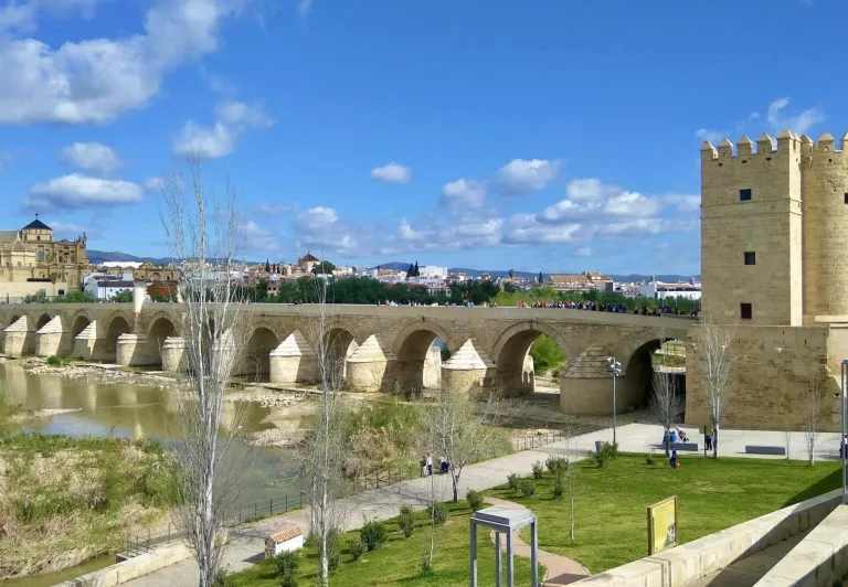 Turistas en el Puente Romano de Córdoba, España, con la Mezquita-Catedral al fondo.