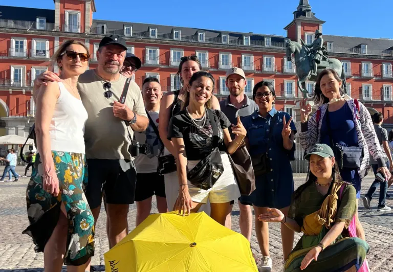 Fröhliche Touristen auf einer WALKATIVE!-Tour am Madrider Plaza Mayor.