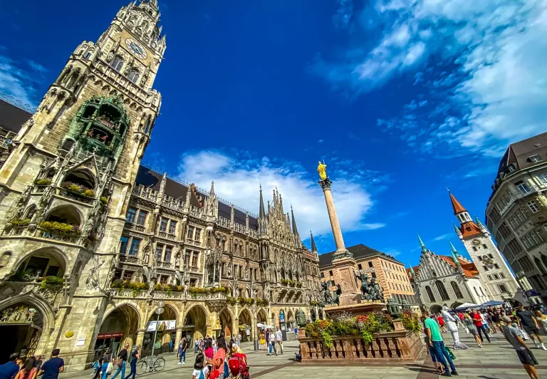Touristen erkunden den Marienplatz in München, Deutschland, mit dem neuen Rathaus im Hintergrund.