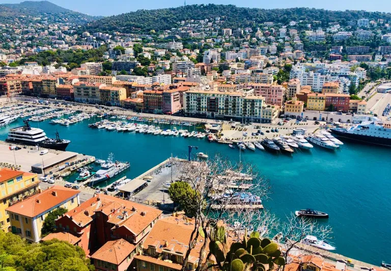 Panoramic view of Nice's harbor, filled with yachts and boats.