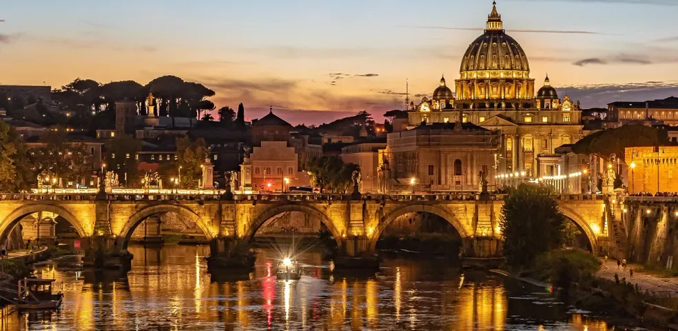 Stunning sunset view of St. Peter's Basilica and Ponte Sant'Angelo in Rome.