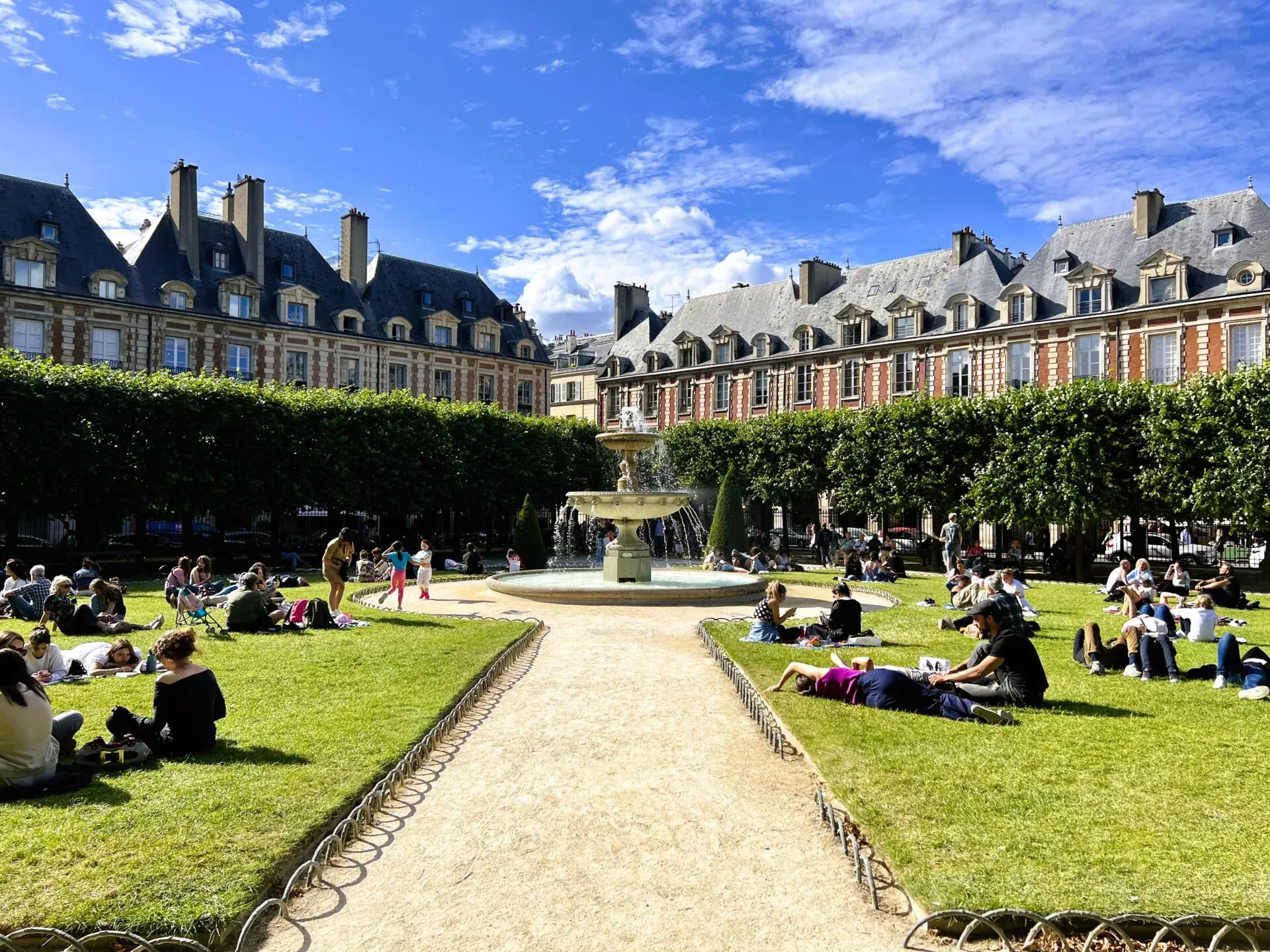 Gente relajándose en una soleada plaza parisina.