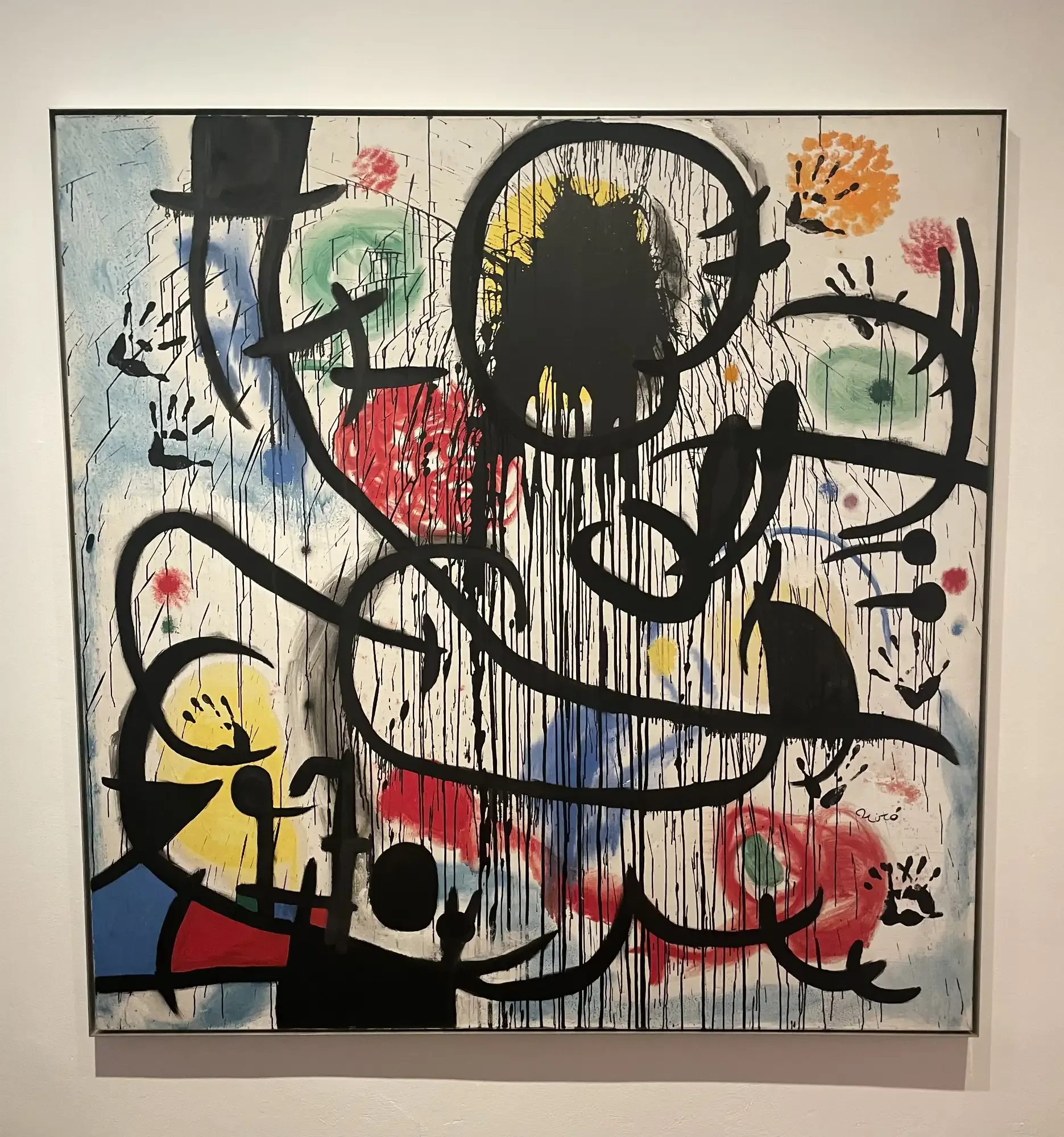 Pintura abstracta de Joan Miró con líneas negras goteando, formas coloridas en rojo, amarillo, verde y huellas de manos.